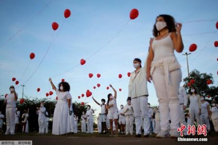 　　资料图：当地时间6月1日，巴西首都巴西利亚，艺术家们手持红色气球悼念在新冠疫情中不幸离世的人们。