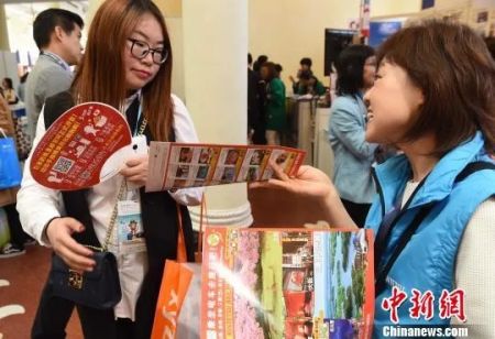　　图为诸多日本企业在发放宣传资料，推介所推出的各项便利措施，吸引更多中国游客。