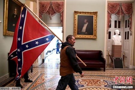 当地时间1月6日，有人手持代表支持蓄奴的“邦联旗”，闯入美国国会大厦。