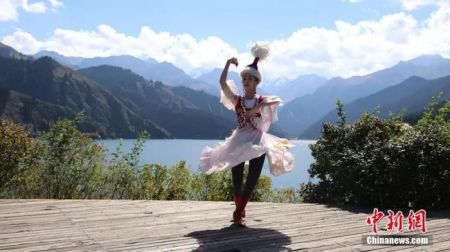 　　资料图：身着哈萨克族服饰的姑娘在新疆天山天池边跳舞。王小军 摄