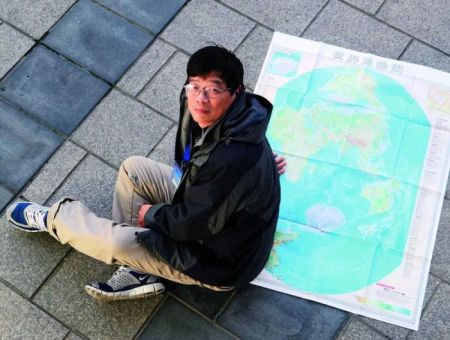 　　中国科学院精密测量科学与技术创新研究院郝晓光研究员与他创新编制的竖版世界地图。