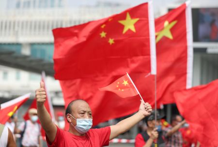 2021年10月1日，香港市民在尖沙咀揮舞國旗。新華社記者 吳曉初 攝