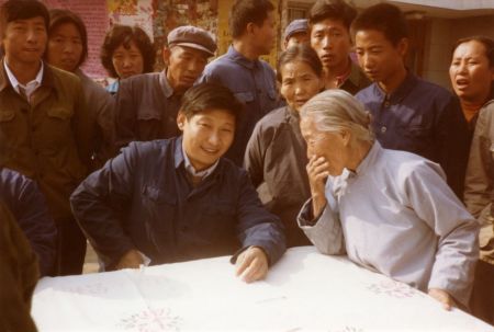 　　这是1983年，时任河北省正定县委书记的习近平，临时在大街上摆桌子听取老百姓意见。新华社发