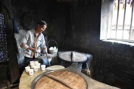 村民正在给游客打现磨豆浆。
