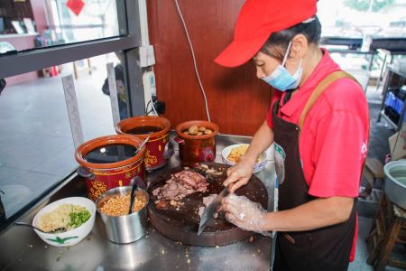 图为桂林米粉文化中心工作人员正在切卤牛肉。陈冠言 摄 图为桂林米粉文化中心工作人员正在切卤牛肉。陈冠言 摄