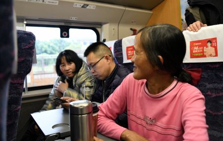 列车靠站时，范氏利（右一）和越南籍旅客阮秋贤（左一）聊天。  中新社记者  蒋雪林 摄