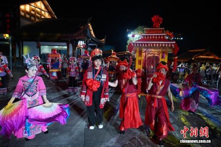 图为传统土家婚俗秀现场，“新郎”迎娶“新娘”。中新社记者 张浪 摄