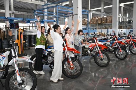 图为海外华媒侨领在生产车间与摩托车合影。中新网记者 何蓬磊 摄 图为海外华媒侨领在生产车间与摩托车合影。中新网记者 何蓬磊 摄