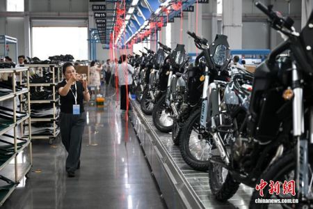图为一位海外华媒代表在生产车间参观摩托车装配生产线。中新网记者 何蓬磊 摄 图为一位海外华媒代表在生产车间参观摩托车装配生产线。中新网记者 何蓬磊 摄