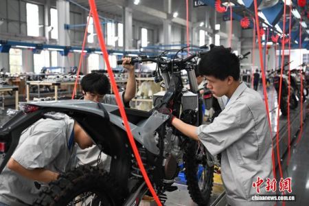 图为工作人员在生产车间组装摩托车。中新网记者 何蓬磊 摄 图为工作人员在生产车间组装摩托车。中新网记者 何蓬磊 摄