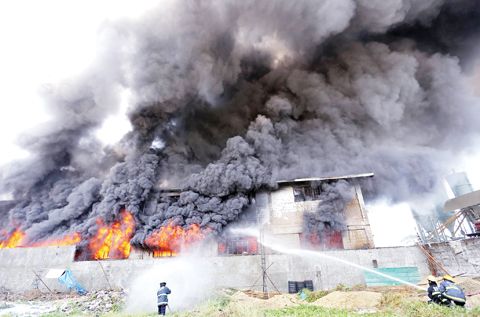 圖為消防員昨天在努力控制描仁瑞拉市的工廠大火。（法新社）