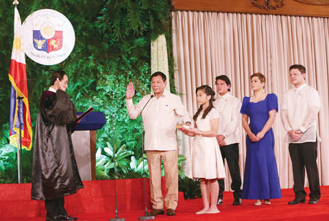 6月30日，菲律賓新總統杜特地在岷里拉宣誓就職，正式開始為期6年的總統任期。圖為杜特地把左手放在小女兒捧著的一本聖經上進行宣誓，他的另外三名兒女在旁見證。在菲律賓今年5月9日舉行的大選中，71歲的杜特地以壓倒性優勢當選菲律賓第16屆總統。