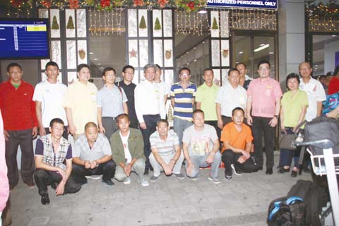 圖為獲釋放的12名中國漁民昨晚在尼蕊·亞謹諾國際機場與前往送行的華社人士合影。