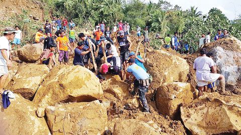 圖為警察和平民志願者昨天在比利蘭省納法爾社發生山體滑坡的地區在巨石中搜尋倖存者。