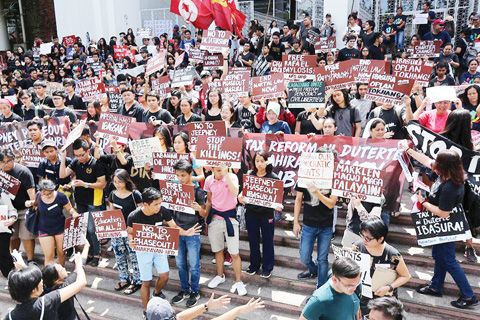 圖為菲國立大學學生昨天走出課堂，參加在計順市迪利曼區菲國立大學巴爾瑪樓前面舉行的反杜特地總統集會。
