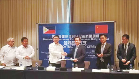 圖為公造部長維惹（左三）和中國公司代表交換簽署合同。