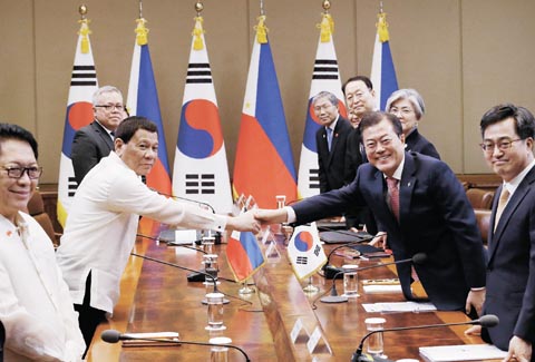 圖為杜特地總統（左二）昨天在韓國首爾青瓦台與韓國總統文在寅（右二）握手。杜特地6月3日抵達首爾進行3天訪問。（法新社）