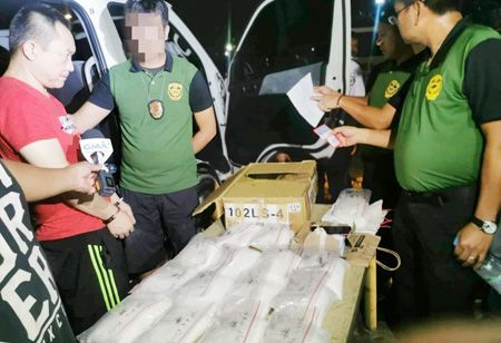 圖為菲緝毒署和計順市警察局的成員出示了價值1.02億披索的沙霧。這些沙霧是從據稱是中國國際販毒集團成員何洪波（音）那裡沒收的。