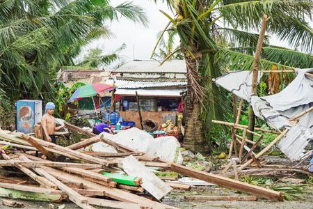 圖為禮智省獨魯曼市一名居民昨天看著一棟被颱風「烏蘇拉」摧毀的房屋。（法新社）