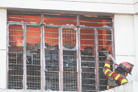 圖為一名志願消防員昨天在馬尼拉敦洛區拉干杜拉街的成衣倉庫滅火。該場大火導致至少16人受傷，包括其東主。