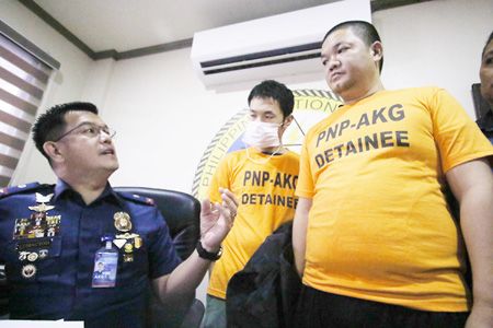 圖為菲國警反綁架組發言人魯麥道（左）昨天向記者展示兩名涉嫌綁架同胞的中國公民。