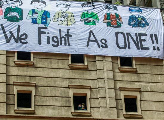 4月12日，在計順市，人們在居民樓上拉出橫幅，表達對在醫護一線與病毒對抗的醫護工作者的支持。（新華社）