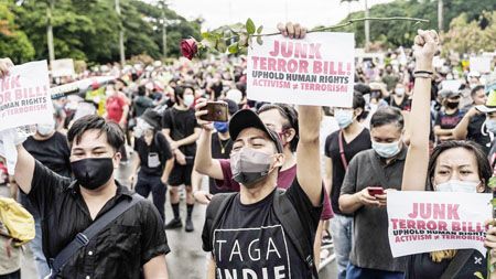 圖為示威者昨日在菲國立大學舉牌示威，反對反恐法。國會議員本月較早通過了2020年反恐法，允許無證拘捕、不起訴拘留數周和其他措施，政府批評者認為這部法律將被用來鎮壓異議分子。（法新社
