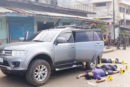 這張未註明日期的照片顯示，在蘇祿省賀洛市，警方開槍打死4名軍人後，被殺士兵的屍體躺在一輛汽車旁。當局正在調查這四名士兵被員警槍殺的事件。（法新社）
