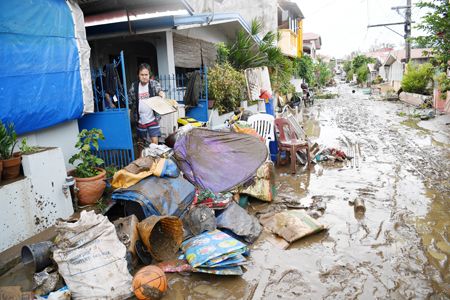 圖為颱風過後，描東岸市的居民在清理屋內淤泥。（法新社）