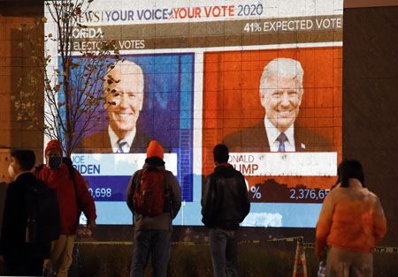 11月3日，佛羅里達州鬧市的大型戶外電視播放美國大選點票的相關報道，不少市民駐足圍觀。（法新社）