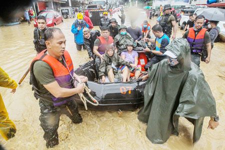 11月12日，在馬尼拉，救援人員幫助被洪水圍困的居民轉移。受颱風「尤利西斯」影響，菲律濱部分地區發生洪水災害。（新華社）