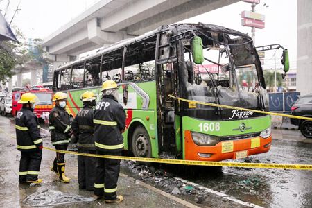 圖為昨日在計順市Commonwealth大街遭縱火焚毀的巴士，已被消防員圍起來。