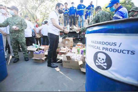 圖為馬尼拉市長莫仁諾昨日在文尼法壽廣場舉行升旗典禮時，檢查將被銷毀的偽劣美容產品。這些偽劣產品都是在岷倫洛華人區非法銷售並被政府沒收的。