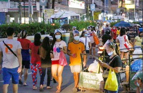 人們昨日戴著口罩和面罩沿著巴蘭玉計市的基仁諾大道行走，以預防新冠肺炎。同一天，菲律濱記錄了創紀錄的7103例新病例，這也是自大岷區進行不同級別隔離一年多以來最高的。