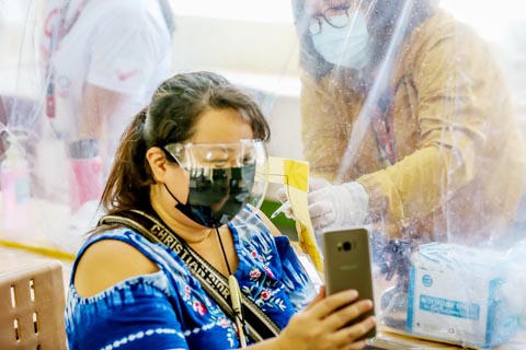 4月7日是世界衛生日，馬尼拉一名居民戴著口罩在接種點接種由中國科興公司研發的新冠疫苗。（新華社）