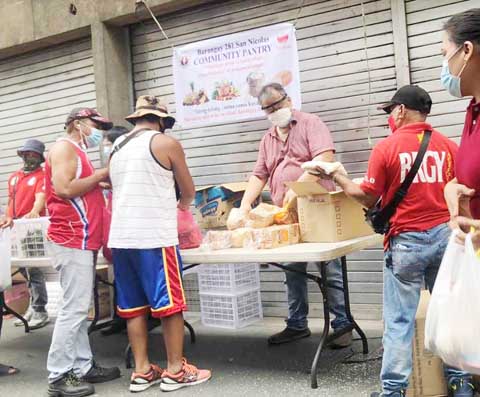 圖為馬尼拉仙尼龜拉示華人區281號描籠涯主席劉少強昨日在雪文街設立社區廚庫,分發食物給有需要的街坊。食物是由區內多名華商捐贈。