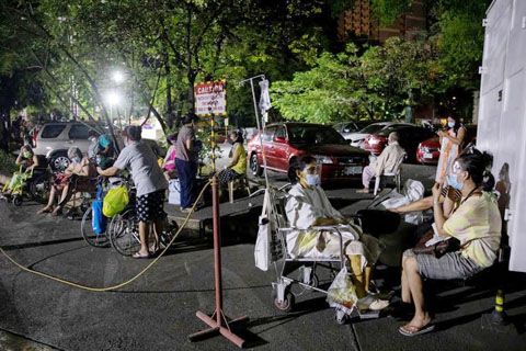 菲總醫院週日凌晨失火，圖為病患們被疏散到醫院外等待轉院。醫院呼籲民眾捐贈工業風扇、氧氣筒、水、食物和口罩等物資。