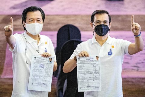 馬尼拉市長莫仁諾（左）和他的競選夥伴許偉利醫生（左）昨日前往巴西市索菲特大酒店花園帳篷提交正副總統參選證書。（新華社）