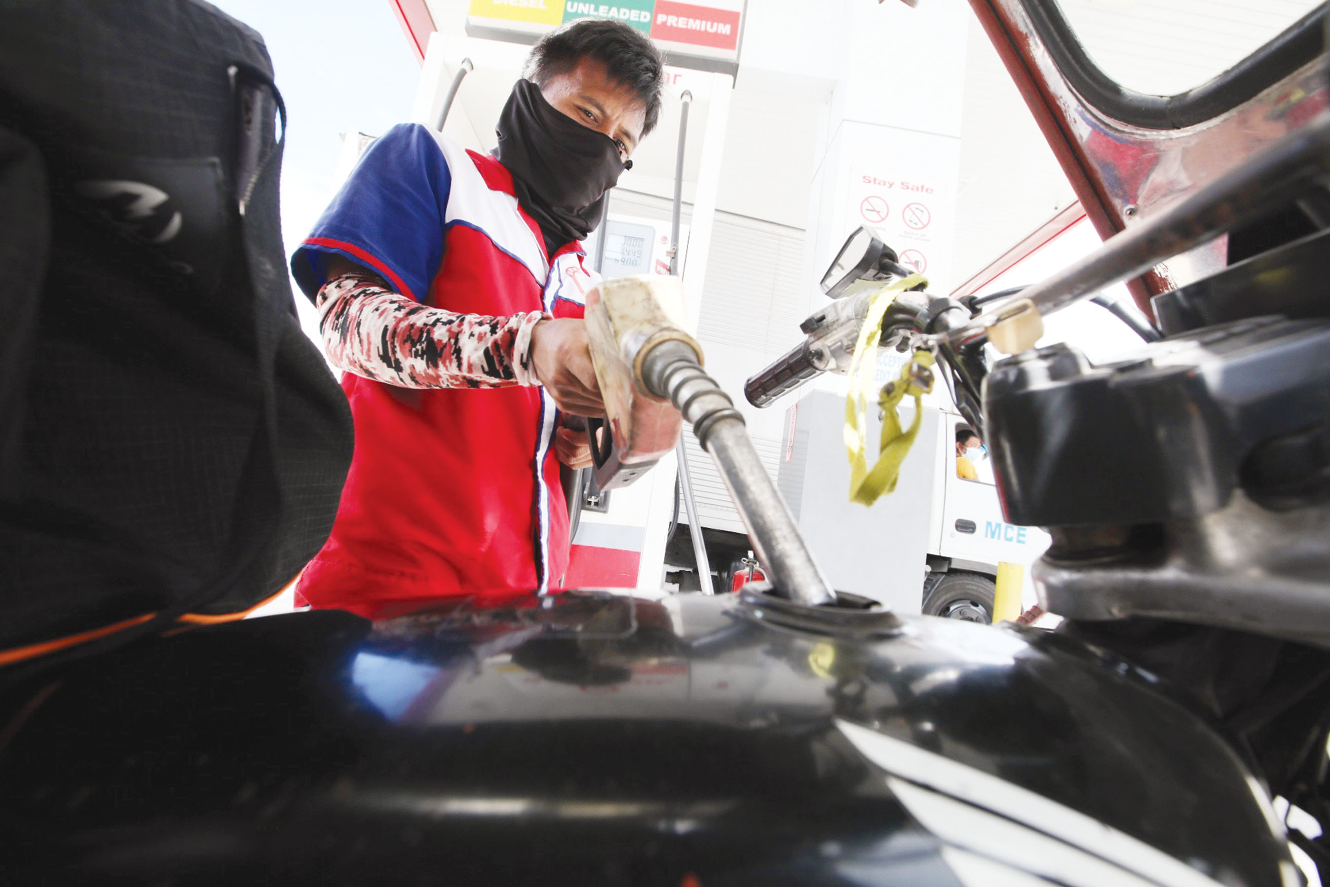 圖為一輛三輪車昨日在甲美地省亞銀那洛高速公路加油站內加油。油價今日將再度上調。