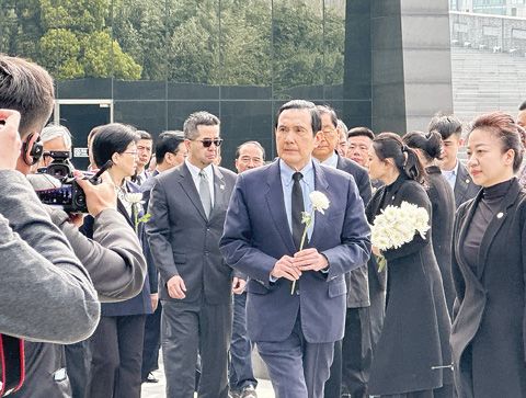 3月29日，中國國民黨前主席馬英九一行參觀了侵華日軍南京大屠殺遇難同胞紀念館，深切悼念遇難同胞。圖為馬英九手持白菊走向「古城的災難」雕塑獻花。（中新社）