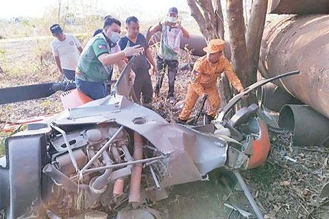 4月11日，甲美地省救援人員正在檢查一架墜毀的訓練直升機殘骸。菲軍方和警方說，這架菲海軍訓練直升機週四在首都以南一個城市公共市場附近的一片草地上墜毀。（美聯社）