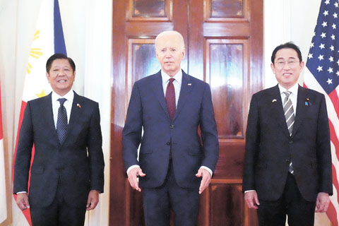 美國總統拜登（中）11日與菲律濱總統小馬科斯（左）、日本首相岸田文雄（右）在白宮舉行峰會。（美聯社）