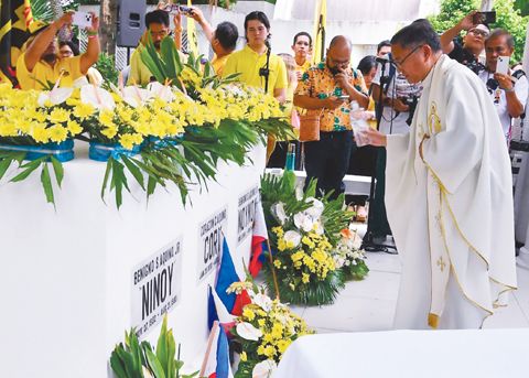 已故前參議員敏勒諾·「尼蕊」·亞謹諾的支持者、友人及家屬，於巴蘭玉計市馬尼拉紀念墓園獻上黃色鮮花與祈禱。今日為尼蕊·亞謹諾日，紀念這位前參議員逝世42週年。