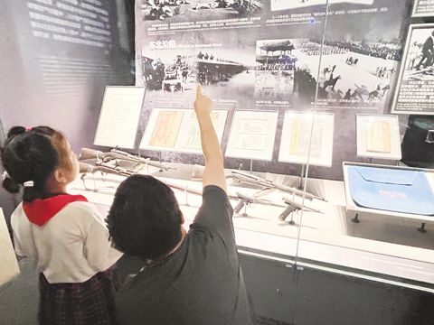 在中國人民抗日戰爭紀念館內,一名父親向女兒講述中國抗戰的歷史。(本報記者蔡友銘攝)