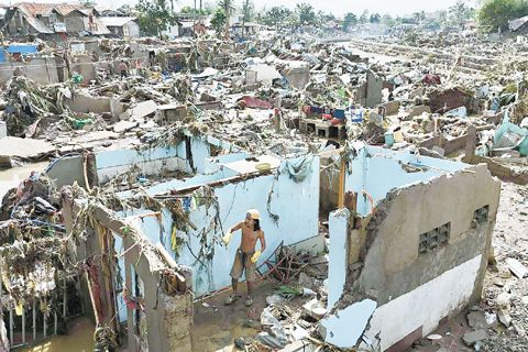 11月5日，在颱風「智諾」摧毀宿務省塔里賽市馬南加河沿岸社區後，一名居民回到他們殘破的家園。（美聯社）
