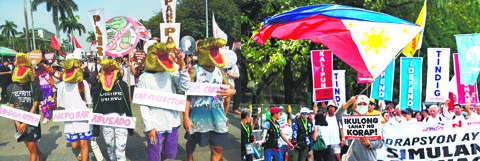 左圖為示威者昨日在倫禮沓的反腐集會上,穿戴鱷魚面具,抗議政府貪污腐敗。右圖為昨日在乙沙人民力量紀念碑的示威者呼籲監禁貪官。(法新社)