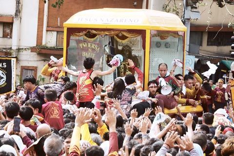 信徒們於1月9日清晨在馬尼拉的亞耶拉橋附近簇擁著黑耶穌聖像。一些人將他們的手帕及其他衣物扔給最靠近神像車輦的信徒，供其擦拭聖像。