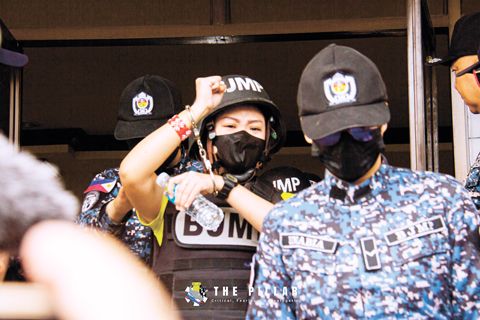 被拘留的記者弗倫奇·梅·昆彪1月22日抵達禮智省獨魯曼地區法庭時做出抗議手勢。