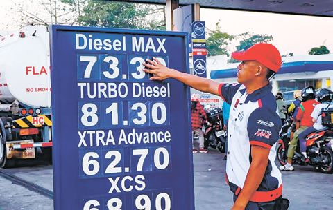 3月11日上午，在又一輪燃油價格調整後，一名加油站員工正在更新位於聯邦大道Philcoa的一座加油站的價格牌。石油公司實施了最新一波影響柴油和汽油的油價調整，與此同時，駕駛人及摩托車騎士持續排隊等候加油。