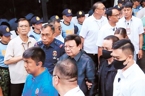 參議員羅丹特·馬科禮沓（中）於週一在計順市廉政法庭被捕時，由警方押送。他因涉嫌掠奪罪而被捕。（美聯社）